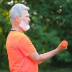 Homme senior actif s'entrainant avec des halteres en exterieur