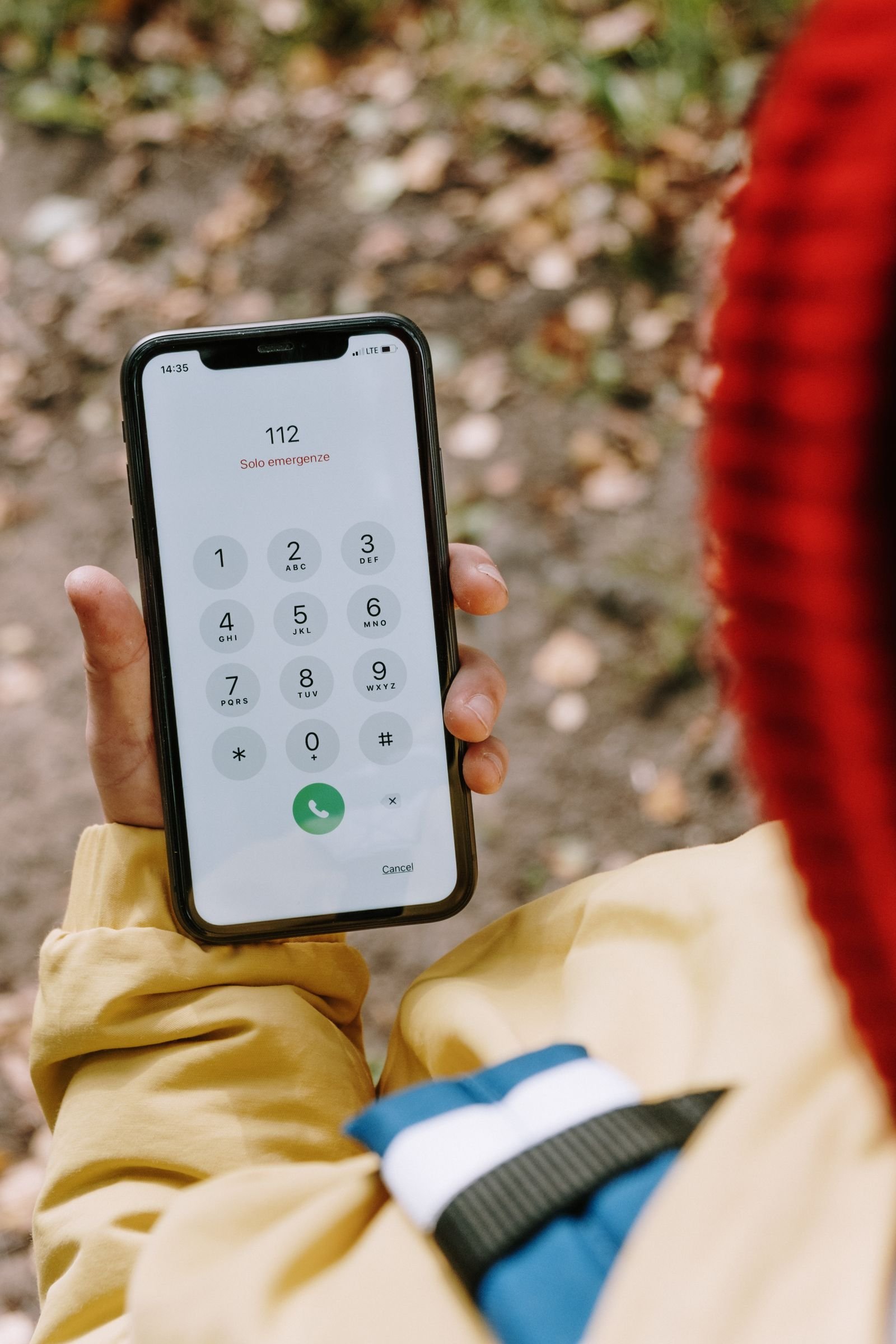 Personne composant un numéro d'urgence sur son téléphone portable