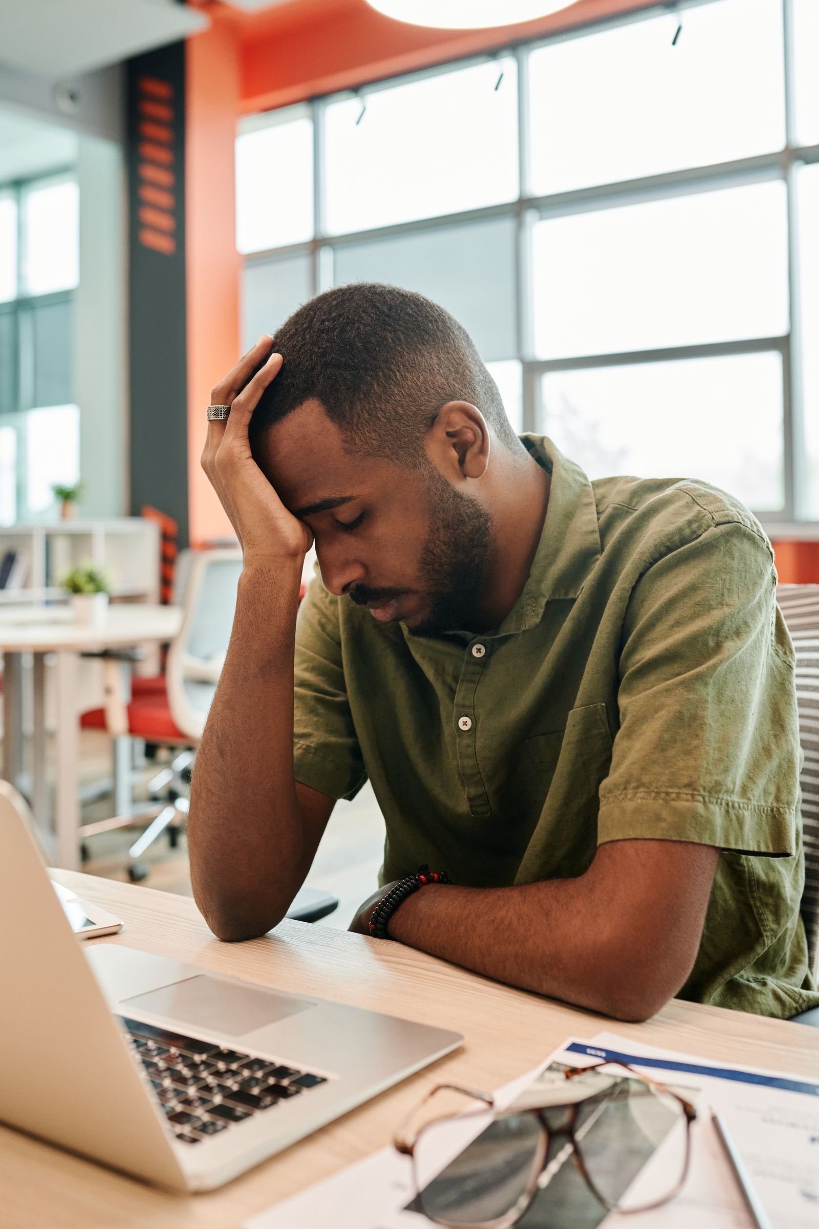 Homme épuisé au bureau, signe possible de fatigue liée à une carence